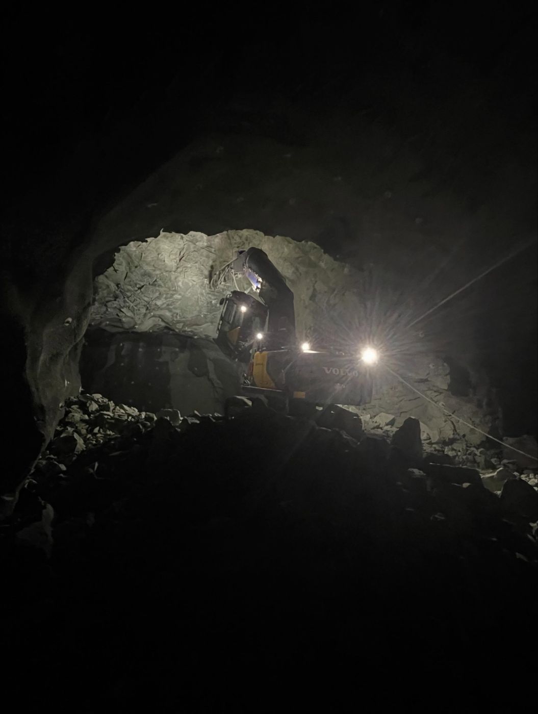 Mørk tunnel med borerigg og lys fra arbeidsplassen